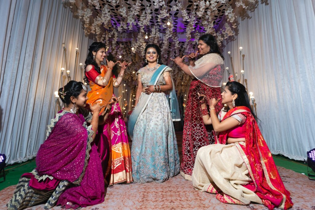 group of women in red and gold sari dress